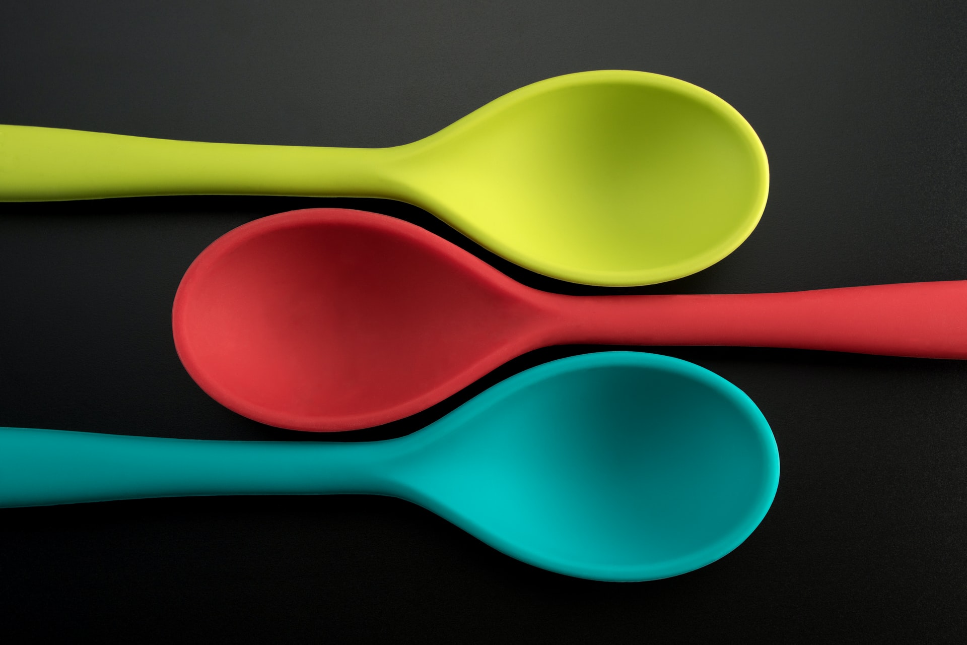 three green, red, and blue plastic spoons